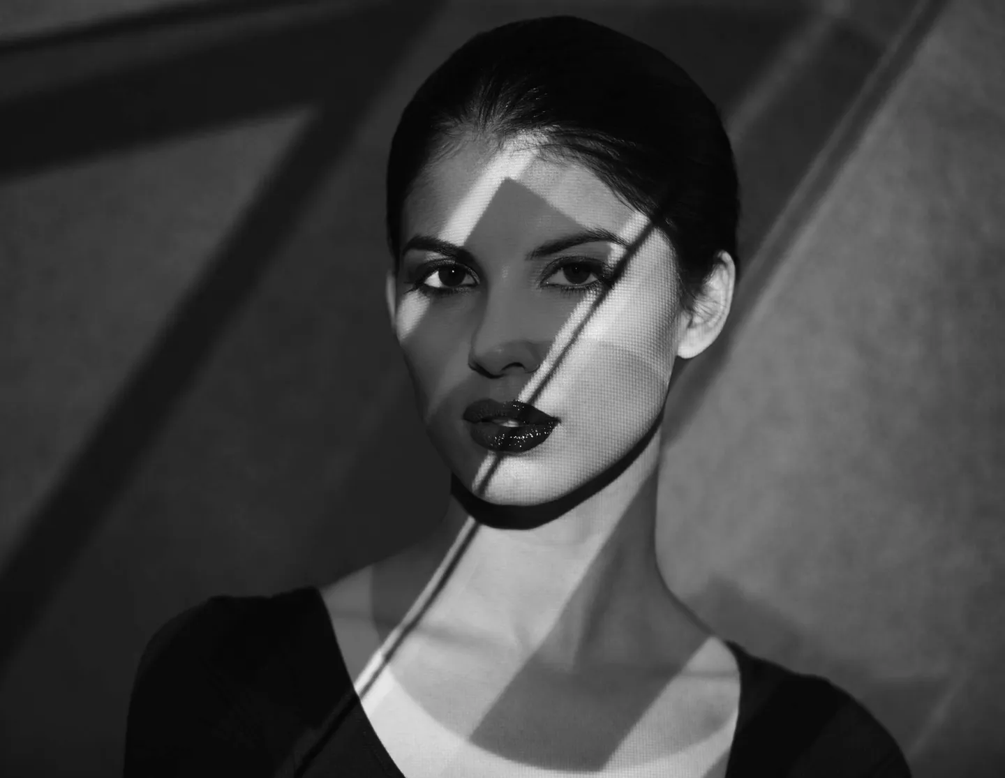 Fashionabel kvinna svartvit bild med sned skuggning över ansiktet