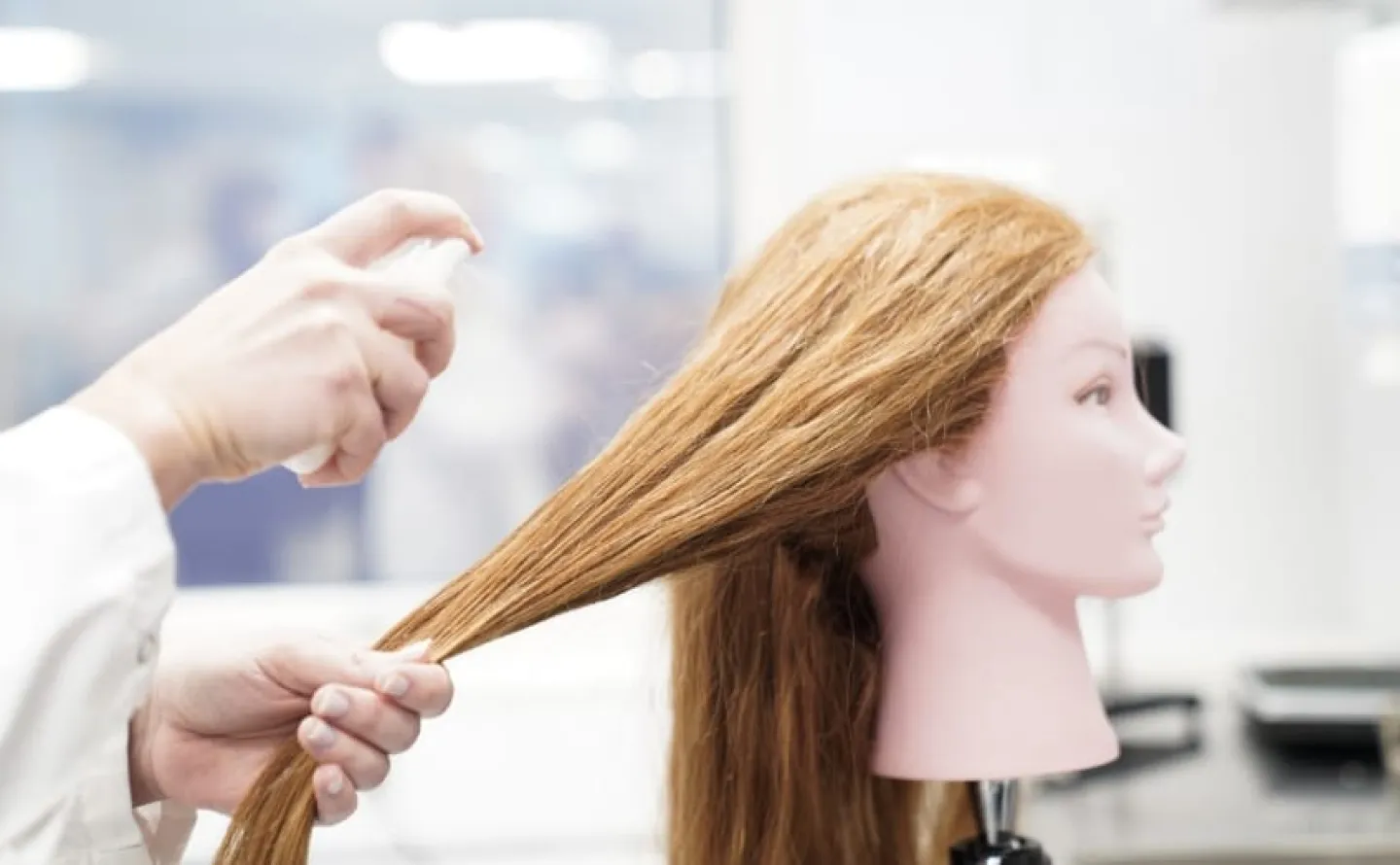 Produkttest på docka med peruk för att testa hår stylingprodukt