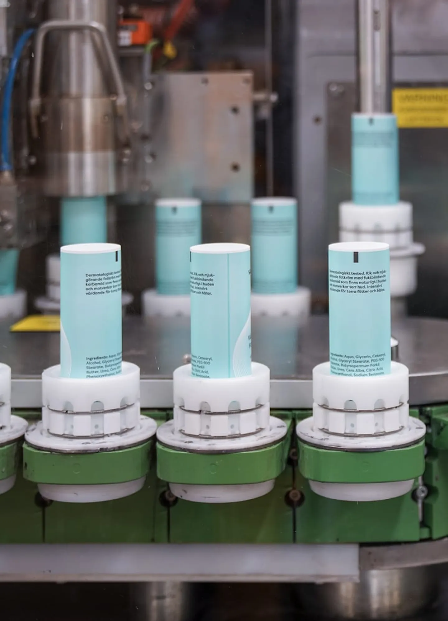 Produktionsled produktionsband där kosmetiska hudvårdsprodukter skapas och hälls i blåa turkosa platsförpackningar