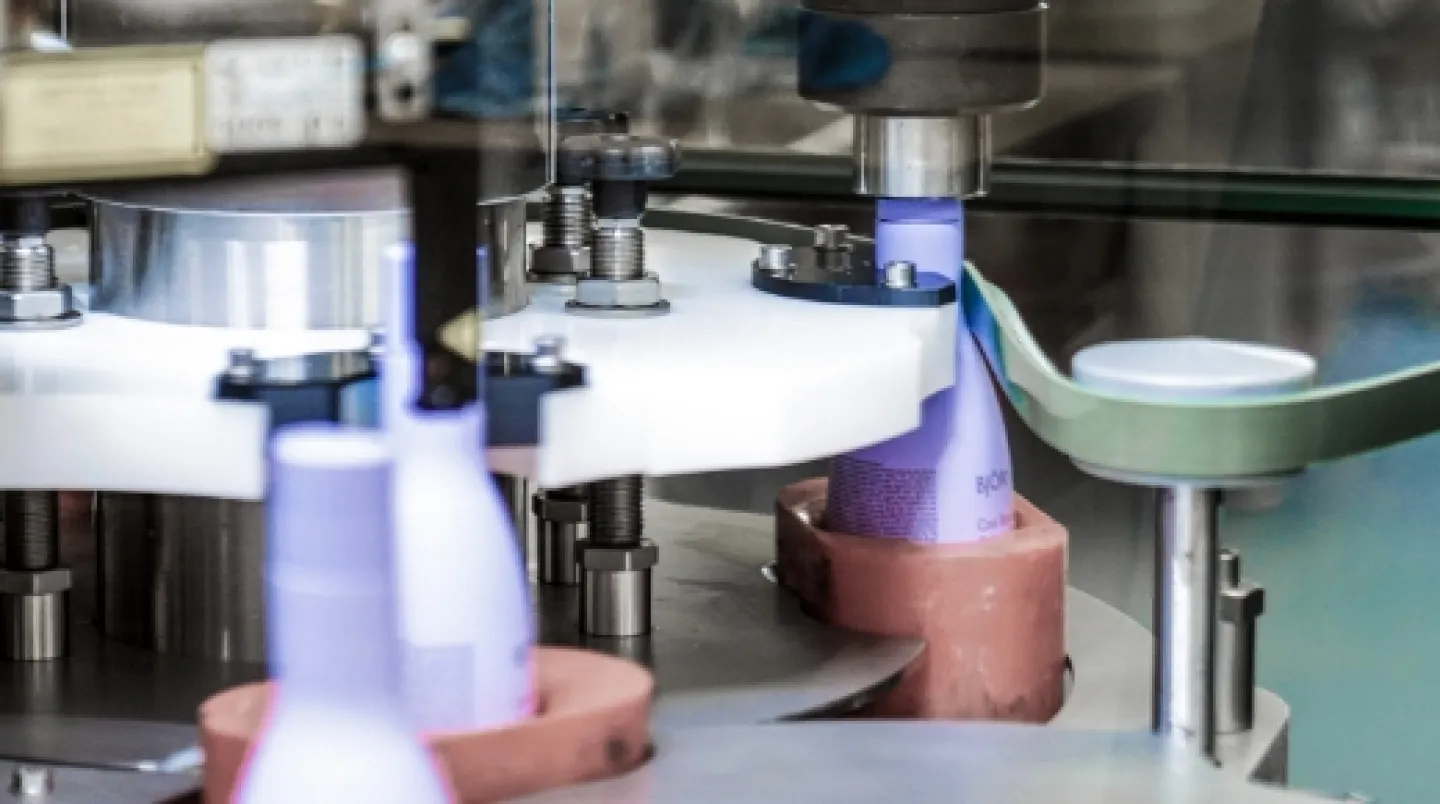 Produktionsband där lila hårvårdsprodukter tillverkas