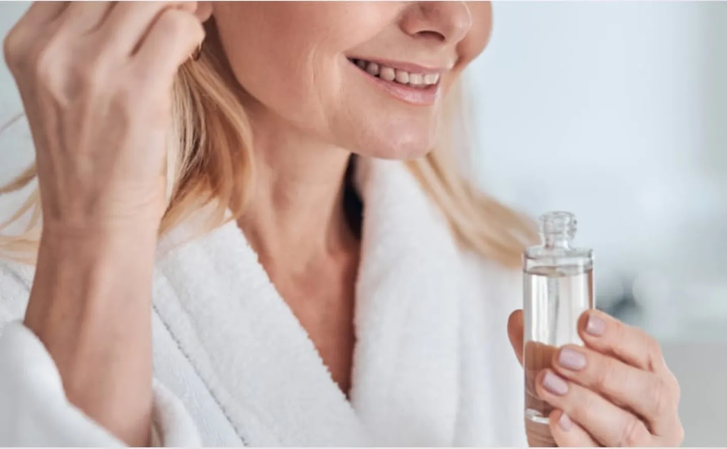 Glad kvinna applicerar hudvård på ansiktet