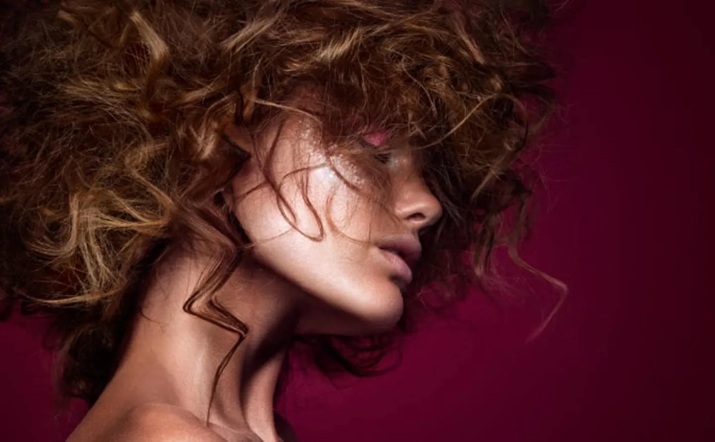 Modell tjej i brunt lockigt hår mot lila bakgrund