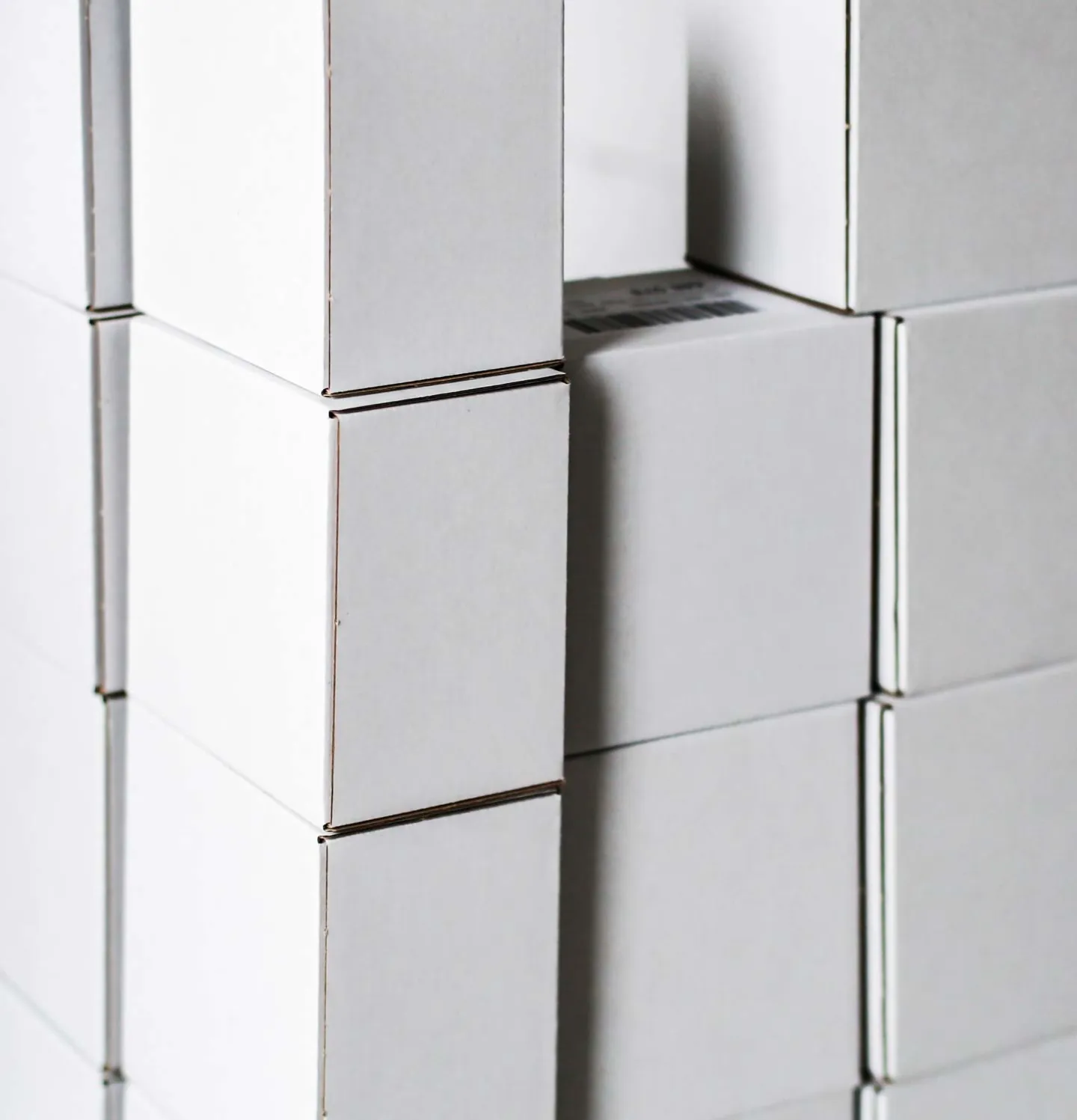 Vita lådor för företagslogistik uppställda på hög