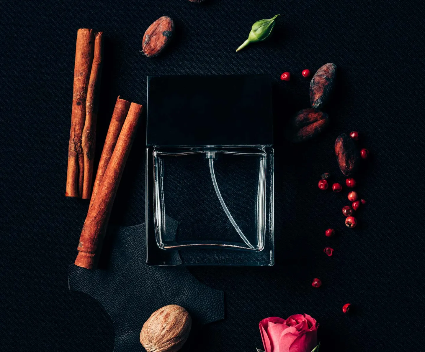 Parfym flaska med olika doft ingredienser bredvid