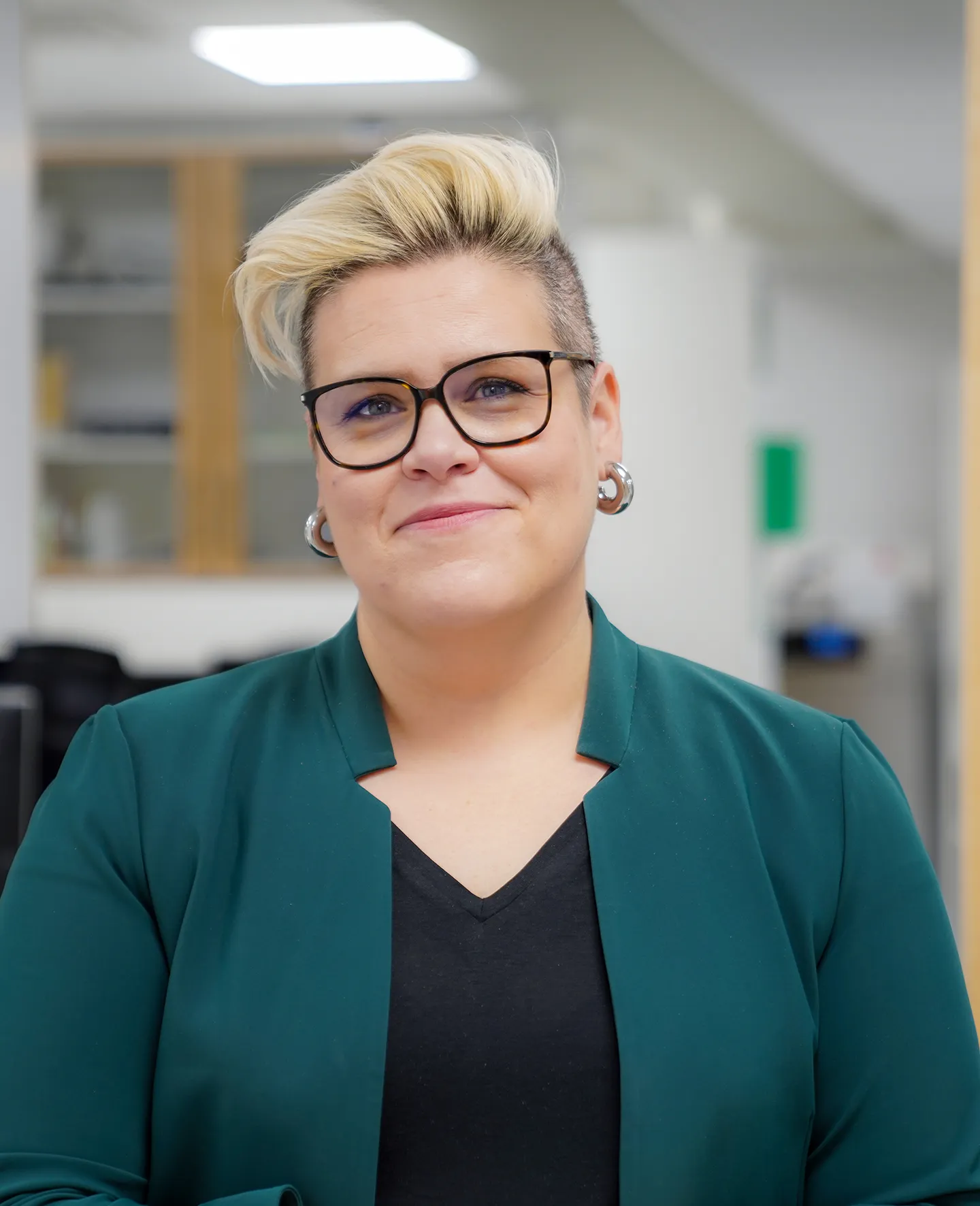 Glad kvinna med glasögon och kort blondt hår