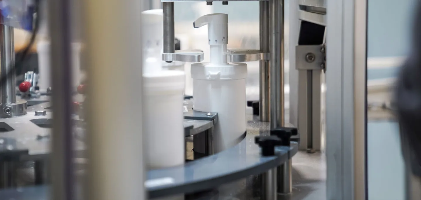 Produktion av hudvård till kroppen i stor pumpflaska på produktionsband