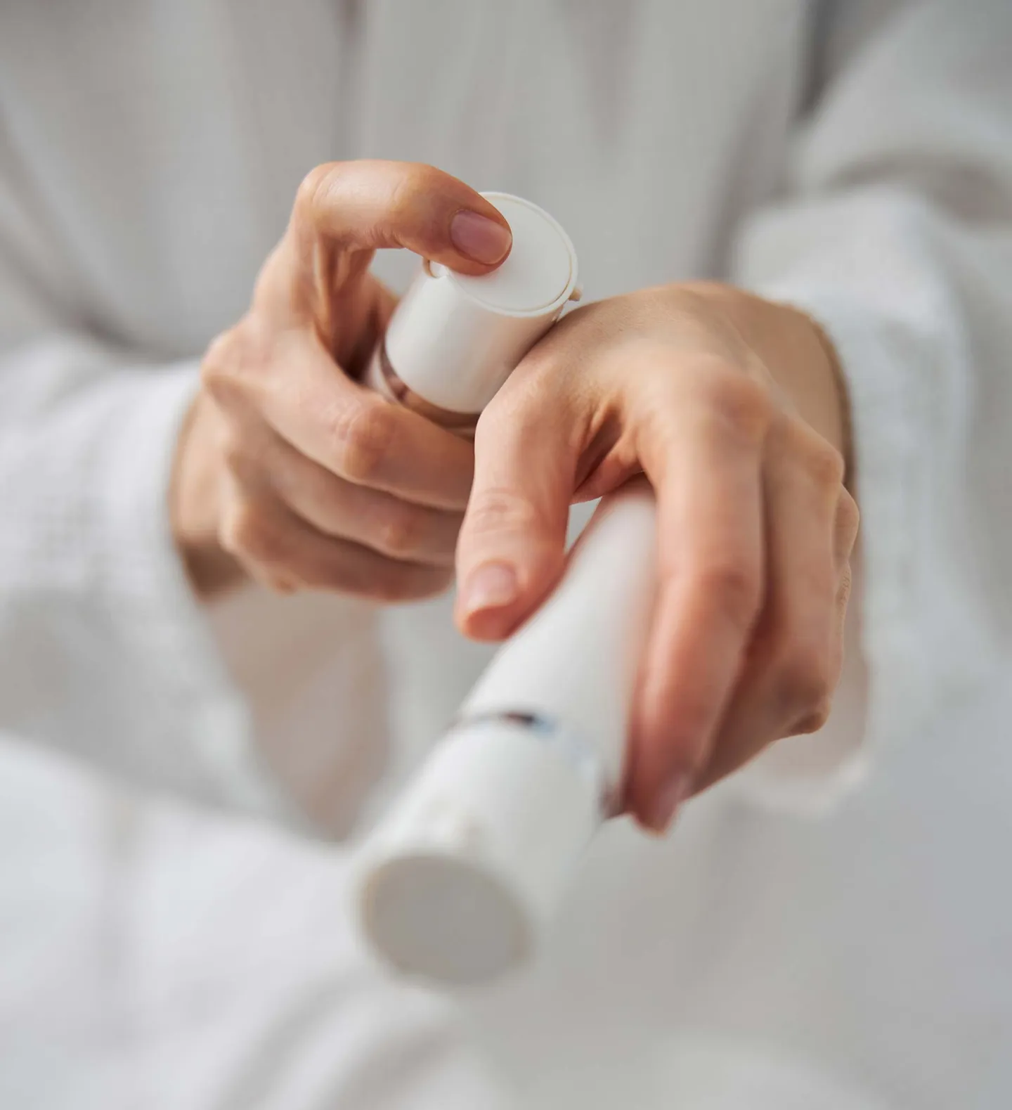 Serum från stilren flaska appliceras på handrygg